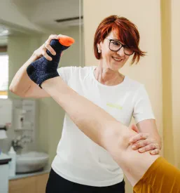 Fizioterapevtka Maja izvaja vodene rehabilitacijske vadbe s pacientko, osredotočene na krepitev in izboljšanje gibljivosti.