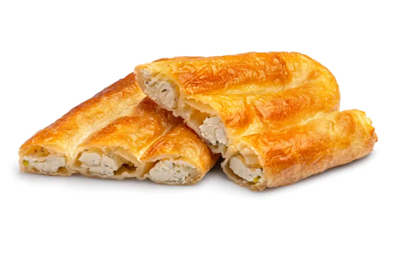 Zapečen vrtičast burek s kremasto sirovo oblogo, postrežen na beli podlagi, poudarja hrustljavo teksturo in privlačen videz.