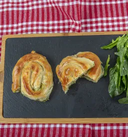 Domači rolan borek, poln sočne špinače in fete, hrustljavo zapečen in pripravljen za uživanje kot okusno pecivo.