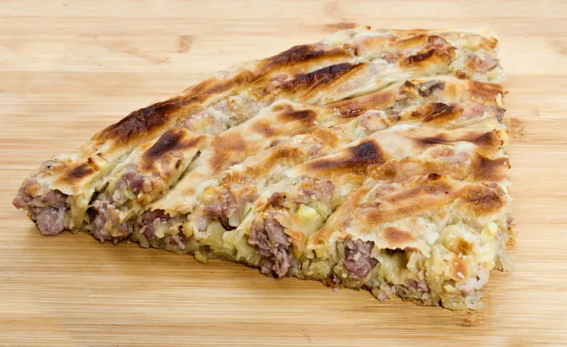 Sočen, tradicionalni bosanski burek z mesnim nadevom, sveže pečen in pripravljen za postrežbo. Naša Pekarna Ljubljana Črnuče ponuja le najboljše bureke.