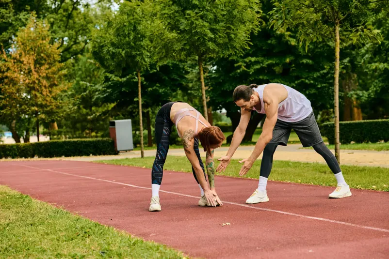 Odločna športnica trenira na atletski stezi, pri čemer jo vodi osebni trener. Idealno za šolo atletike Borovnica.