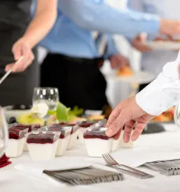 Skrbno pripravljene sladice za poslovni catering, elegantno razstavljene na mizi za praznovanje podjetja.
