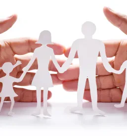 Hands protecting cutout of a family