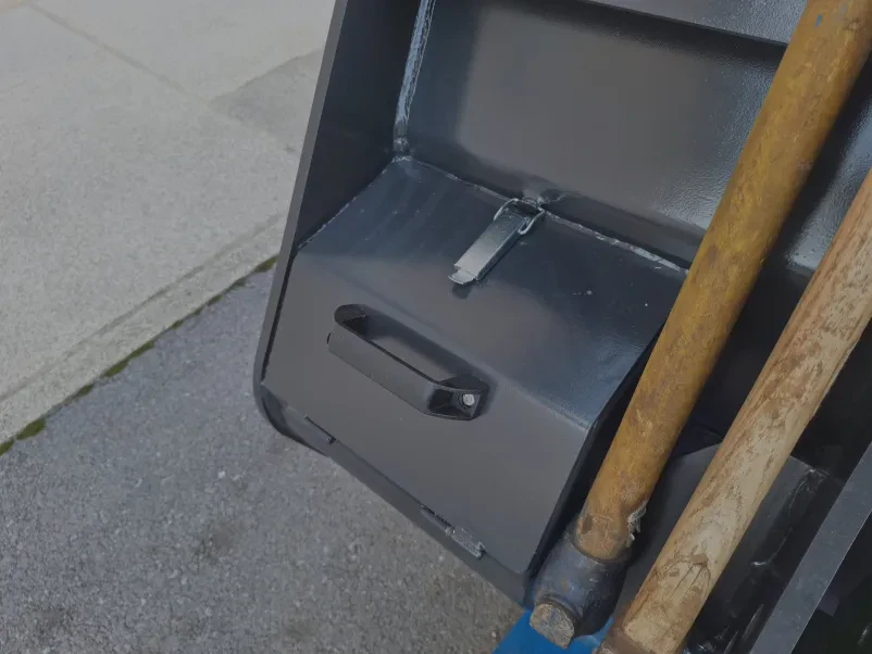 Kmet z našo mehanizacijo na njivi Kmet vozi traktor, opremljen s česačo, med obdelovanjem polja, kar kaže na učinkovitost česala in traktorski platoji Sežana, Slovenija.