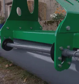 Traktor z robustno rampirno desko stoji v gozdu, pripravljen za premikanje hlodovine, kar predstavlja del gozdarske mehanizacije.
