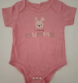 Majhen otrok s koncentracijo raziskuje barvito igračo na mizi, ki spodbuja interakcijo in učenje skozi igro.