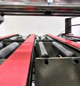 Detajl sodobnega avtomatiziranega stroja z robotiziranimi rokami, ki prikazuje napredne rešitve v industrijski proizvodnji.