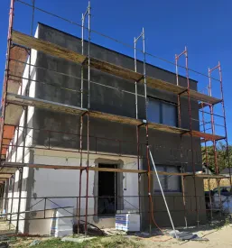 Moderna stanovanjska hiša z veliko teraso in urejeno okolico. Prikazuje visoko Kvalitetna izvedba stanovanj na ključ Štajerska.
