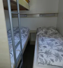 Vesela skupina mladih sodeluje pri zabavni dejavnosti na prostem, uživajoč v naravnem okolju.