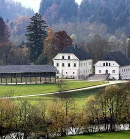 Impresiven zunanji posnetek Dvorca Visoko s pogledom na park in arhitekturo, ki priča o zgodovini.