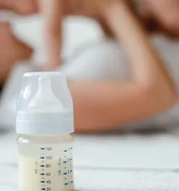 Nežna mati objema svojega dojenčka in izraža skrb, kar je ključno za program za starše in online predavanja za starše Slovenija.
