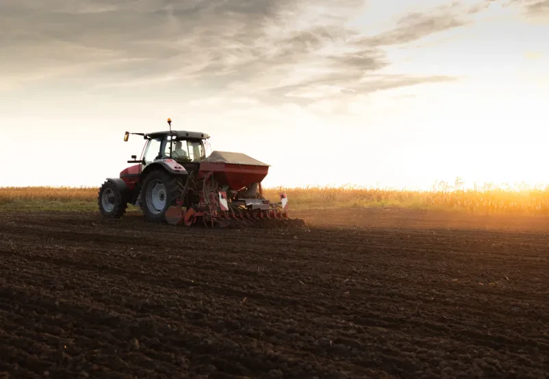 Traktor sejalnica na polju ob sončnem zahodu Zmogljiv traktor s priključenim sejalnim strojem sadi poljščine na obsežnem kmetijskem polju, kar kaže na sodobno kmetovanje. Prodaja in odkup kmetijskih strojev in naprav Slovenija ponuja tovrstno opremo.