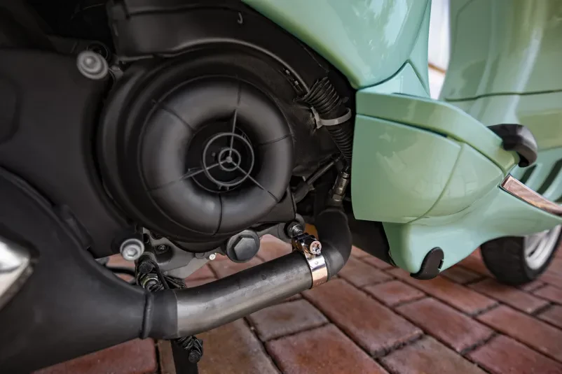 Cevna objemka nameščena na motorju Vespe Visokokakovostna cevna objemka, ki zanesljivo pritrjuje del na motorju klasične Vespe, zagotavlja stabilnost in dolgo življenjsko dobo. Izdelava objemk je precizna.