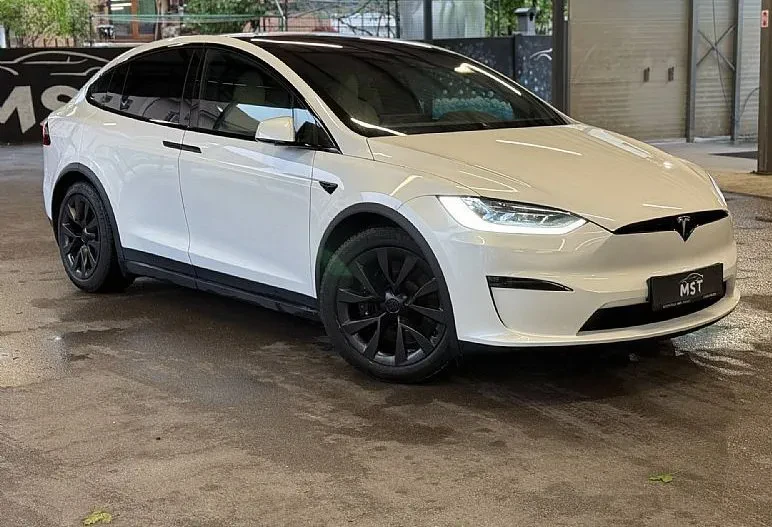 Eleganten Tesla taxi na postajališču Elegantno belo vozilo Tesla, idealno za Taxi prevozi in prevozi do letališča Slovenija, Italija, čaka na postajališču.