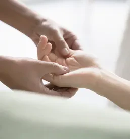 Stranka mirno leži na masažni mizi, ovita v brisače, pripravljena na popolno sprostitveno izkušnjo in razvajanje telesa.