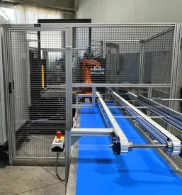 Robotska roka v dinamičnem gibanju med avtomatizirano proizvodnjo, poudarjajoč napredne rešitve v strojegradnji.