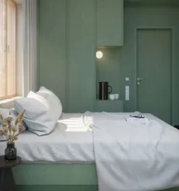 Soba z zelenim lesenim ozadjem in udobna postelja v hotelu Čezsoča.