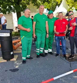 Zaposleni iz Komunale Trebnje pozirajo za skupinsko fotografijo na gradbišču.