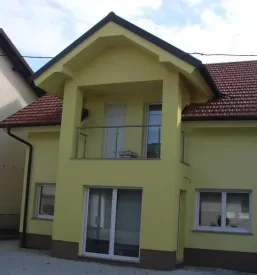 Objekt z novo fasado, pobarvano v rumeno barvo.