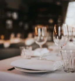 Lepo pripravljena miza s krožniki in priborom, ki čaka na goste zabave zaključene družbe.
