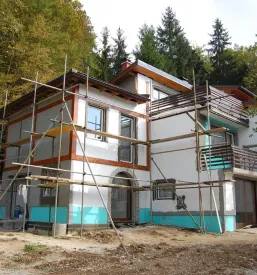 Gradnja enodružinske hiše okoli katere stojijo gradbeni odri, okolica objekta je neurejena in čaka na dela za urejanje dvorišča.