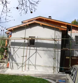 Novogradnja, okrog katere so nameščeni gradbeni odri za delo, okolici objekta poteka urejanje okolice.
