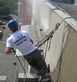 Zaposleni s čelado na glavi opravlja višinska dela pri sanaciji objektov na Gorenjskem.