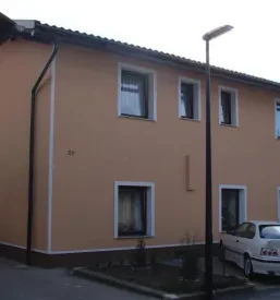 Večstanovanjski objekt, na katerem je podjetje prenovilo fasado in jo na novo pobarvalo v marelično barvo.