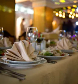 Miza s priborom in pogrinjki, ki so pripravljeni za catering na zasebni zabavi na Obali.