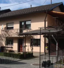 Večstanovanjska hiša z novo fasado marelične barve.