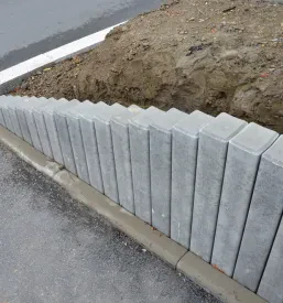Betonske palisade kvadratnega profila s poševnimi stopniščnimi loki, ki se uporabljajo za reševanje manjših višinskih razlik v vrtni arhitekturi in urejanje zelenice.