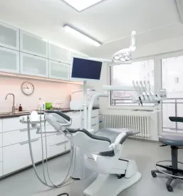 Približan pogled na udoben in ergonomsko oblikovan zobozdravniški stol v svetli in sodobno opremljeni ordinaciji.