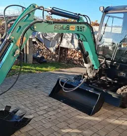 Pogled od blizu na robusten bager s hidravlično roko in veliko izkopno žlico.