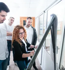Predavateljica pred zaposlenimi predstavlja praktične primere komunikacije med prodajnim razgovorom.