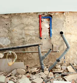 Bližnji posnetek nedokončane kuhinje, kjer so vidne predpriprave za električne in vodovodne inštalacije.