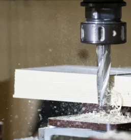 Moderen CNC rezkalni stroj v mizarski delavnici natančno obdeluje les. To omogoča izdelavo kompleksnih in unikatnih kosov pohištva.