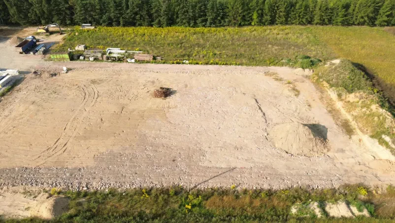 Pripravljeno zemljišče za gradnjo Veliko gradbišče z izravnano in očiščeno parcelo, pripravljeno za zemeljska dela. Obdelan teren čaka na začetek gradnje objekta.